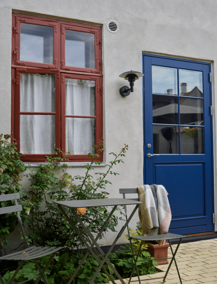 Hellbraunes Haus mit rotem Fenster und blauer Tür