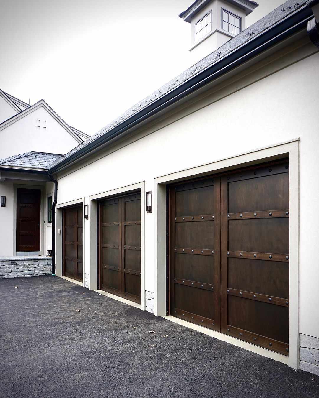 Garagentore aus dunklem Holz mit Metallakzenten.