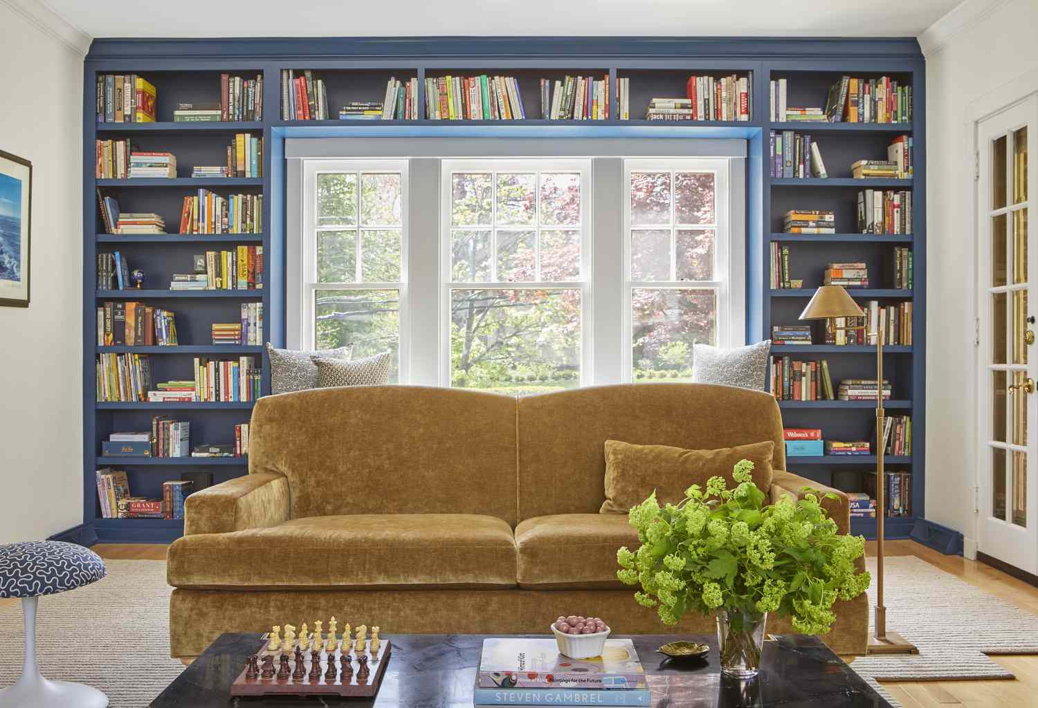 Blaues Wand-zu-Wand-Bücherregal in einem Wohnzimmer.