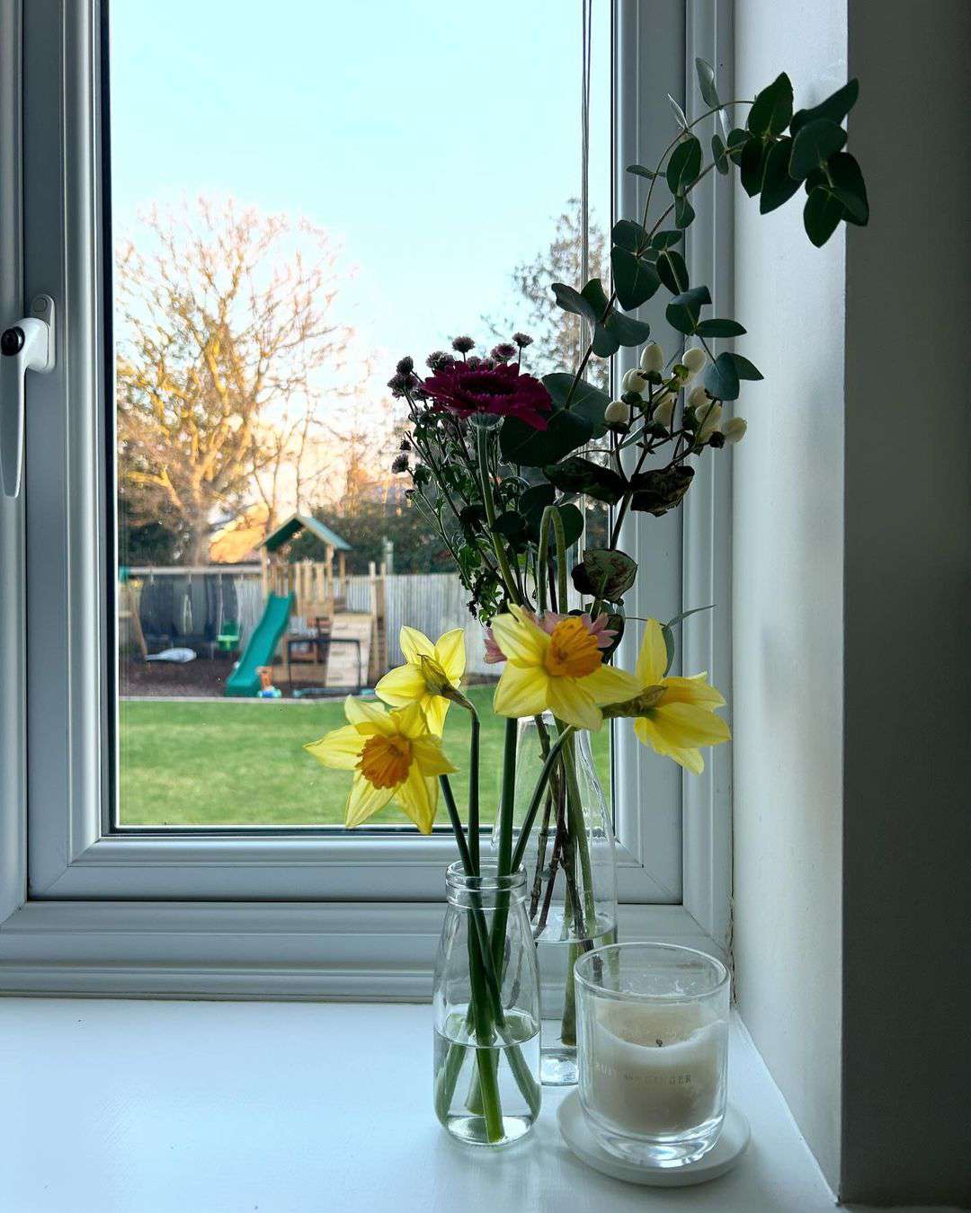 Blumen und Kerze auf der Fensterbank