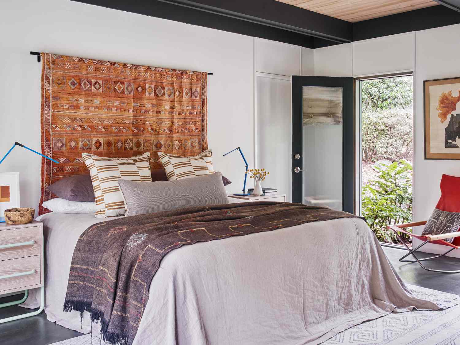 8 Designer-Approved Bedroom Decorating Tricks That Cost Less Than They Look 2 Printed Rug hung from curtain rod to create the effect of a headboard