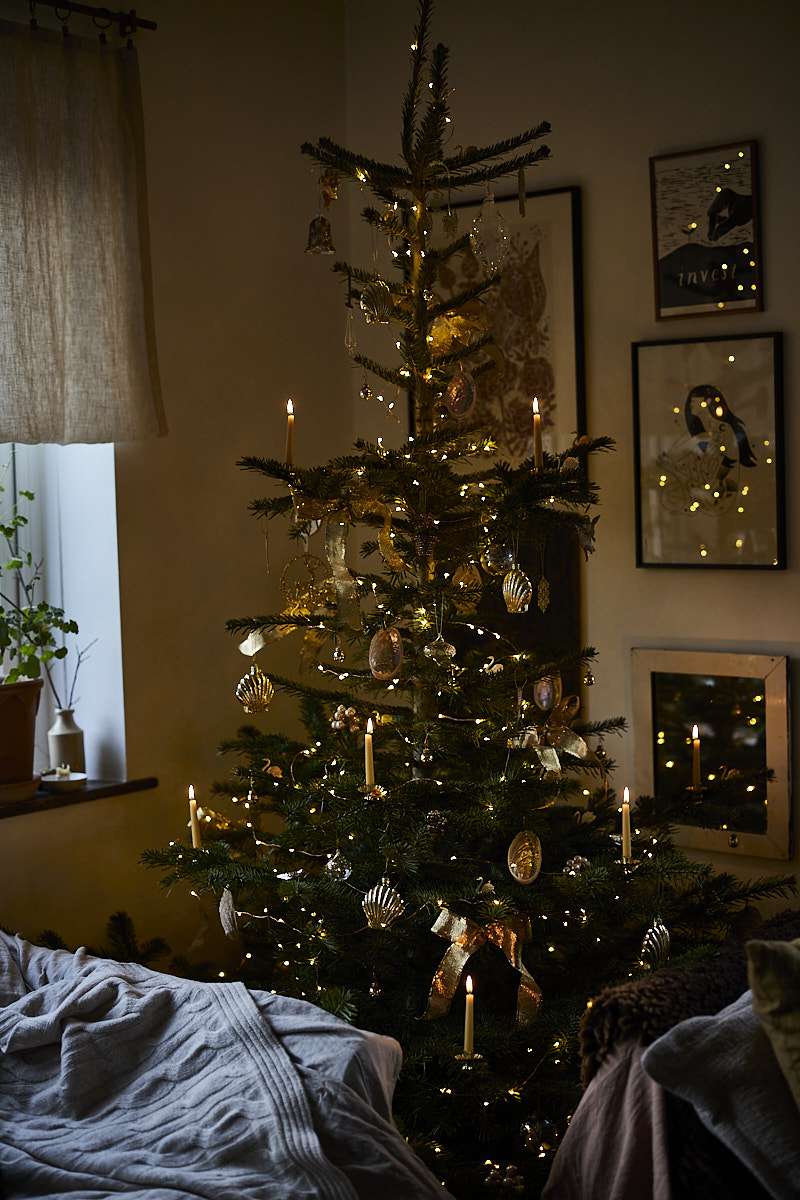 rustikaler Weihnachtsbaum mit echten Kerzen beleuchtet