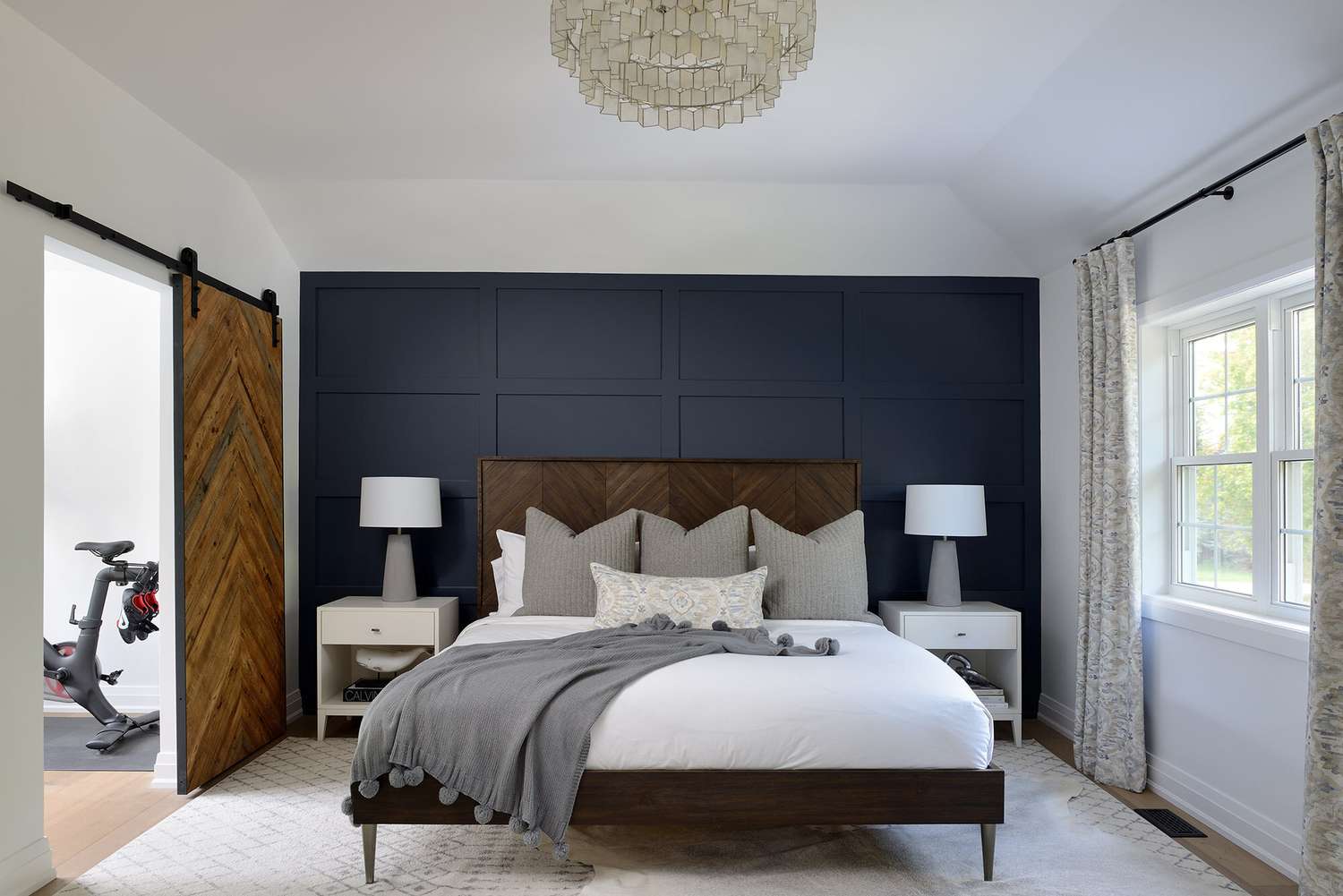Ein elegantes Schlafzimmer mit einem Chevron-Holzbett und einer passenden Chevron-Holzscheunentür
