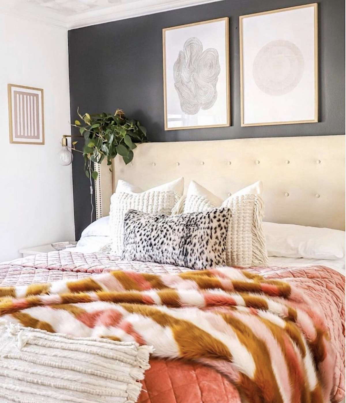 Schlafzimmer mit dunklen Wänden, höherem Kopfteil, Fotos in der oberen Hälfte