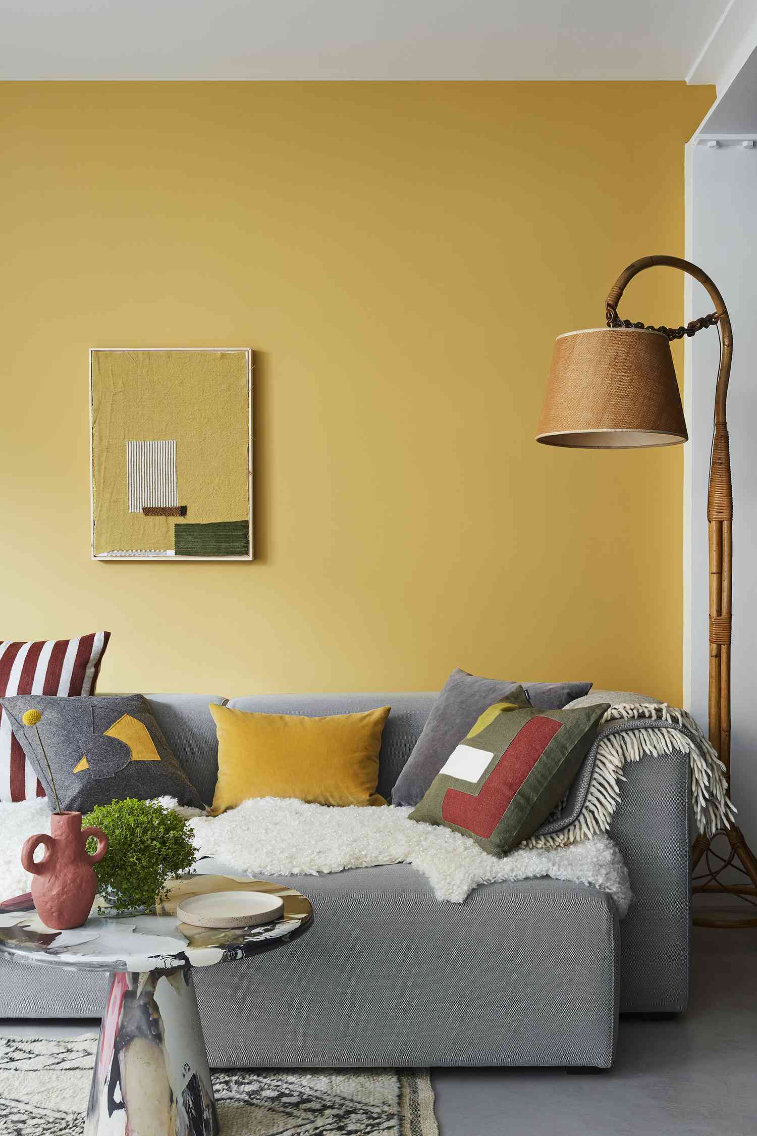 gelbe Wand und graues Sofa