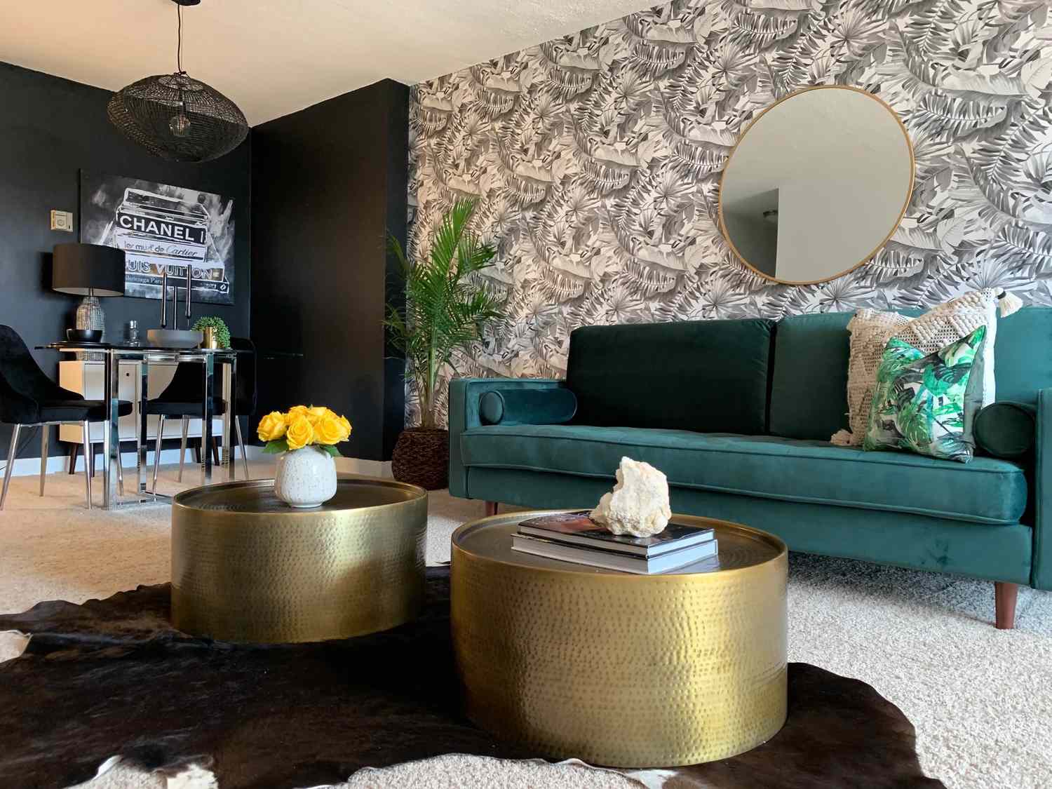 Wohnzimmer mit rundem Goldspiegel.