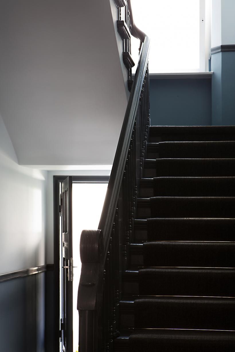 Schwarz lackierte Treppe mit schwarzem Läufer