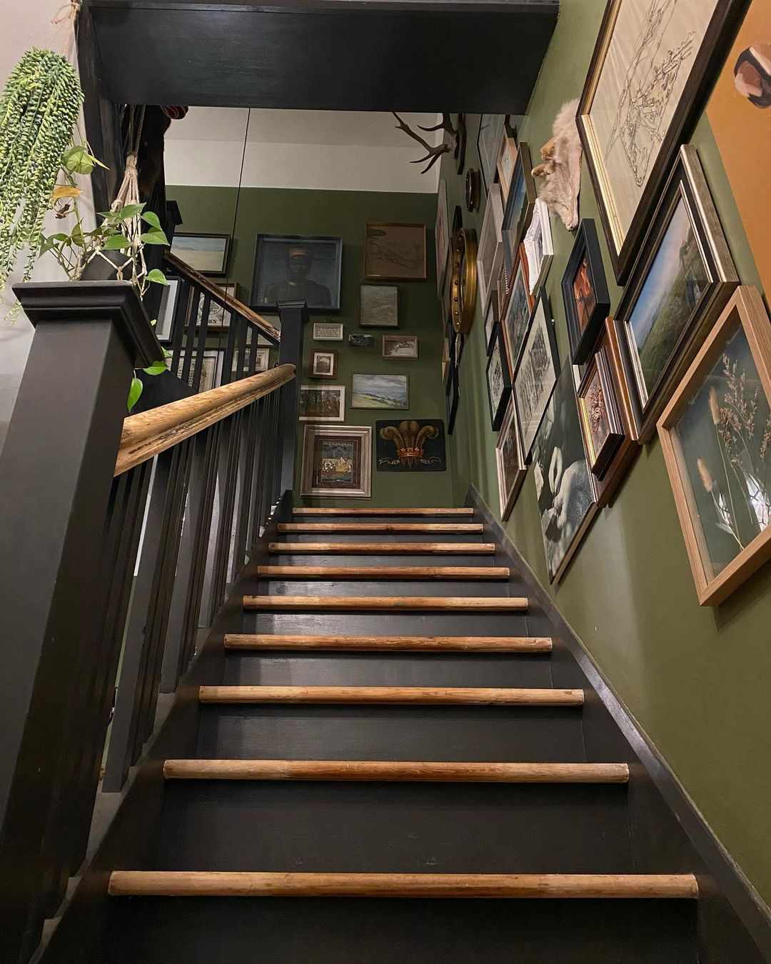 Grüne Wände und stimmungsvolle Galeriewand im Treppenhaus