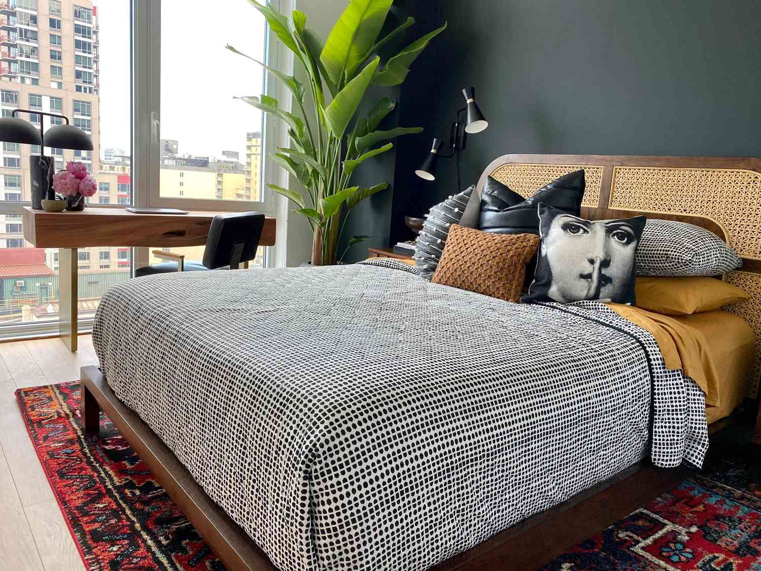 Schlafzimmer mit schwarzer Akzentwand und offenen Fenstern, Blick auf die Stadt