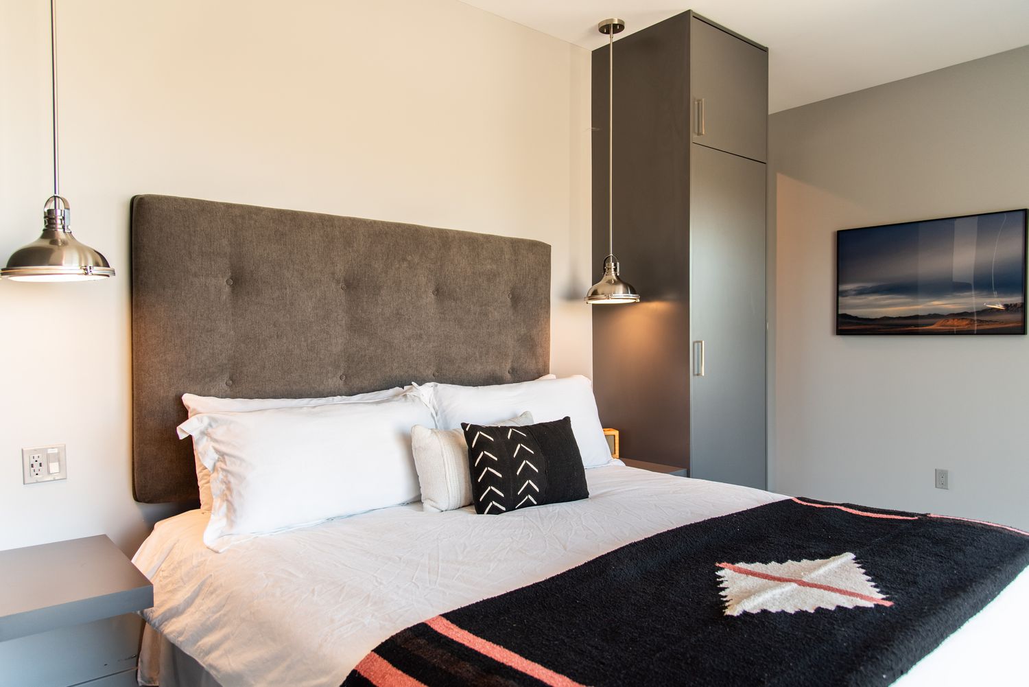 Schlafzimmer mit Hängelampen an beiden Seiten des Bettes und schwebenden Nachttischen