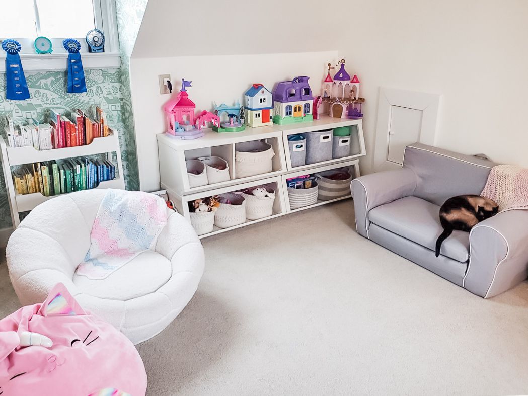 Zimmer mit schräger Decke, Regalen für Kinderspielzeug und Bücher