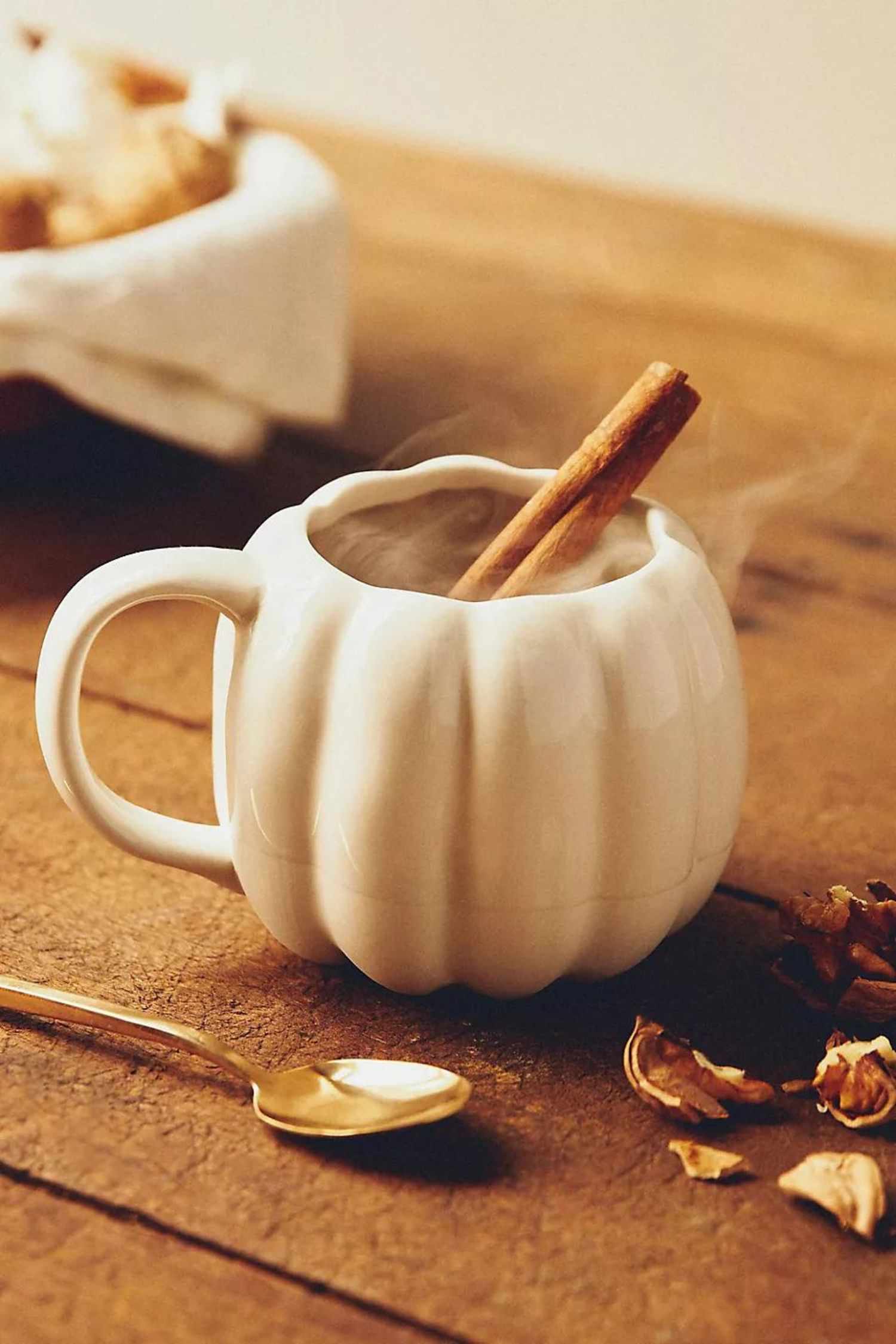 14 Herbstdekorationen von Anthropologie, die Sie nicht verpassen sollten, alle unter 20 $ 6 Ein weißer, kürbisförmiger Keramikbecher mit einem Heißgetränk und einer Zimtstange