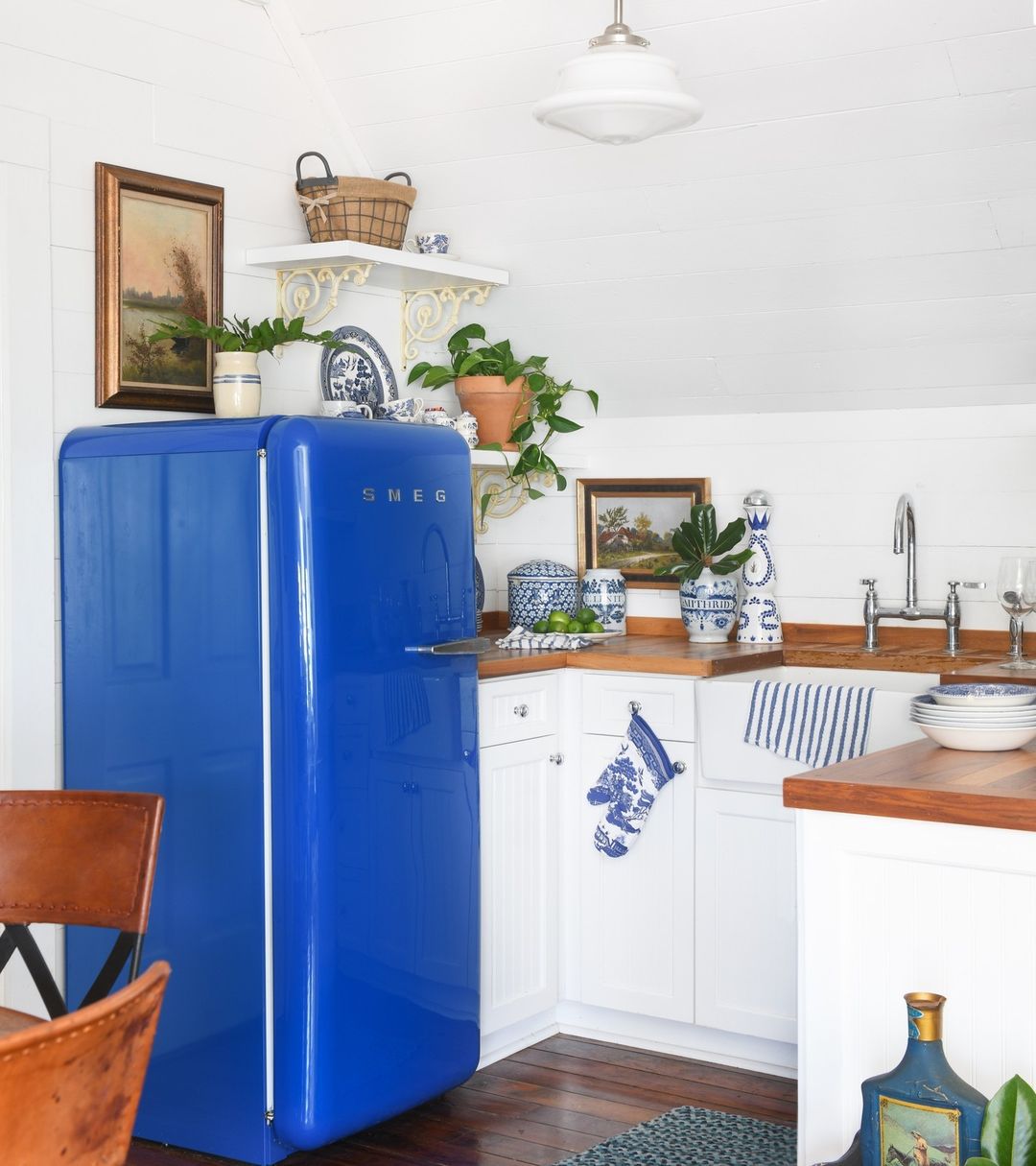 Eine kleine Landhausküche mit einem leuchtend blauen Kühlschrank im Vintage-Stil