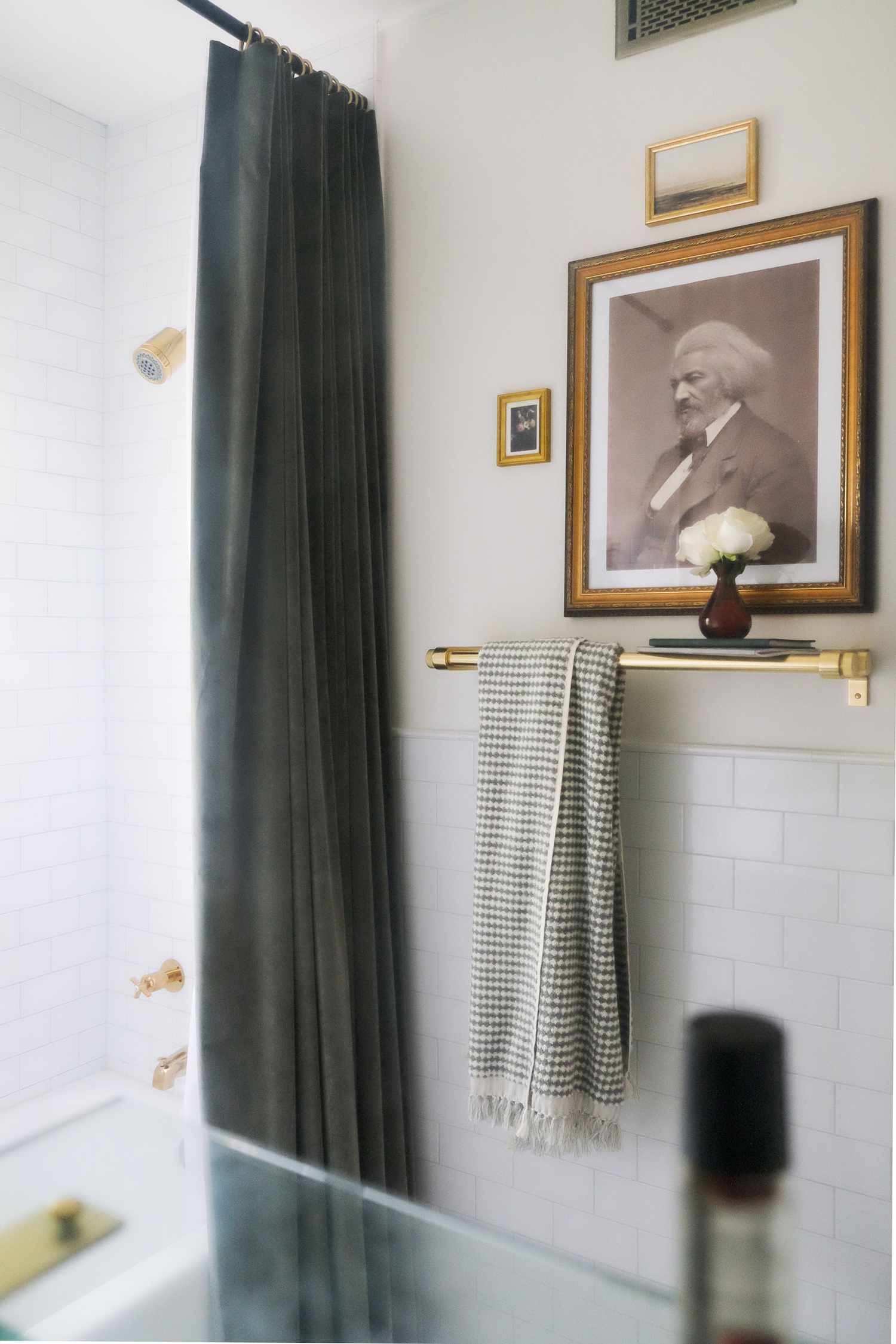 In diesem kleineren Badezimmer ist ein Bild von Frederick Douglass in den Farben Schwarz, Grau, Weiß und Beige zu sehen, das das afroamerikanische Erbe feiert
