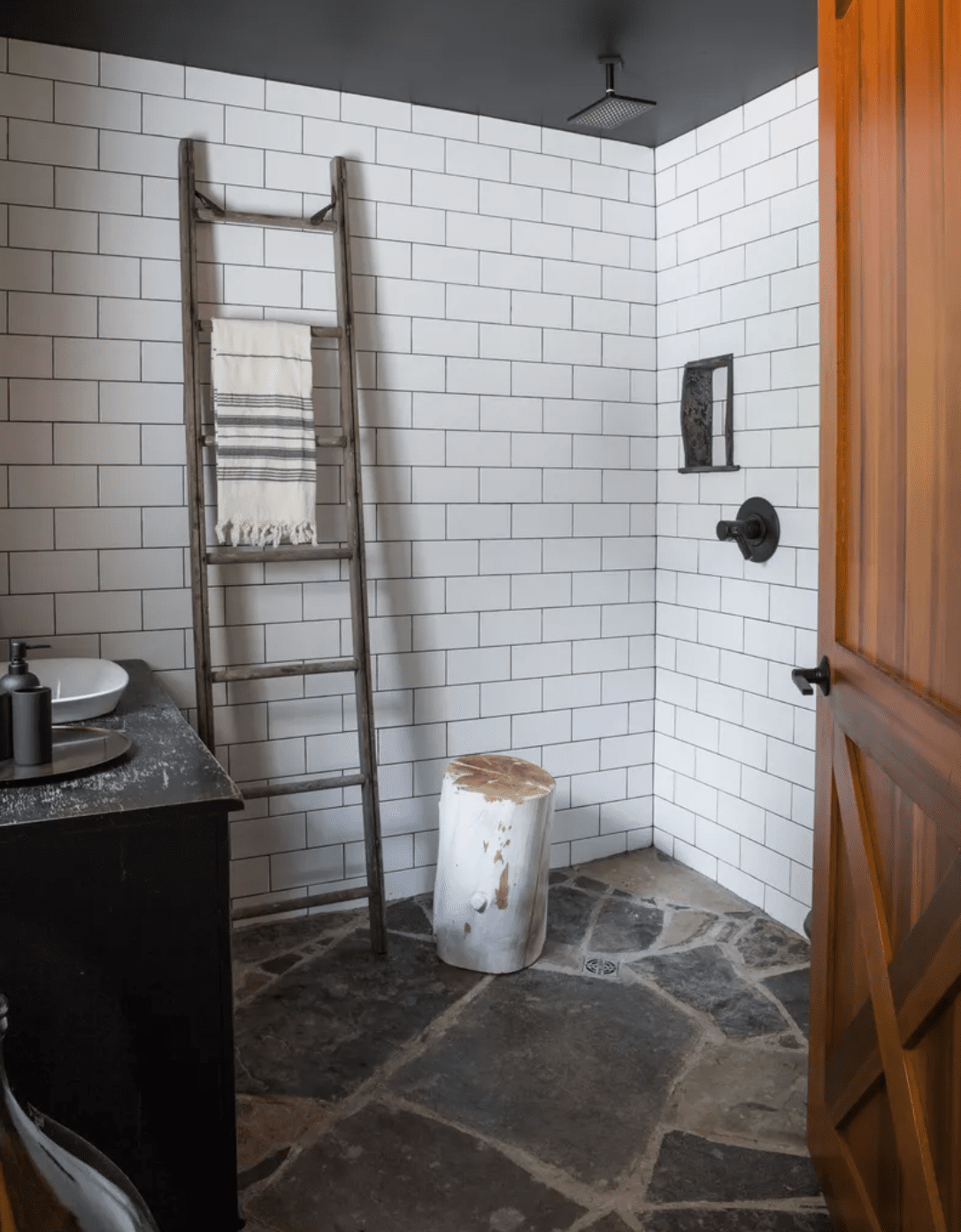 Ein Badezimmer mit Dusche, gefliesten Wänden und Steinböden