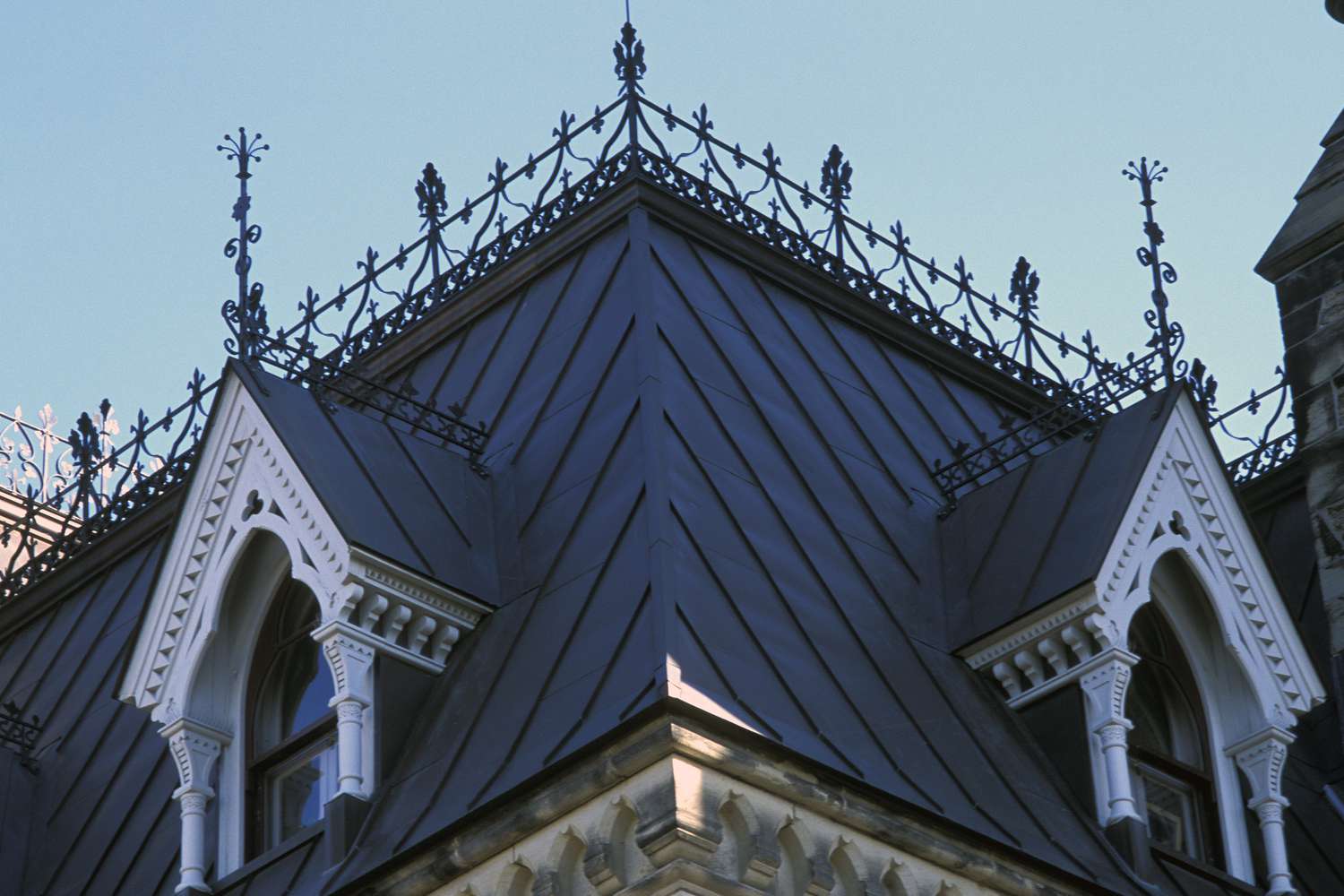 Detail der reich verzierten Giebelgaubenfenster vom steilen Hang eines Mansardendachs