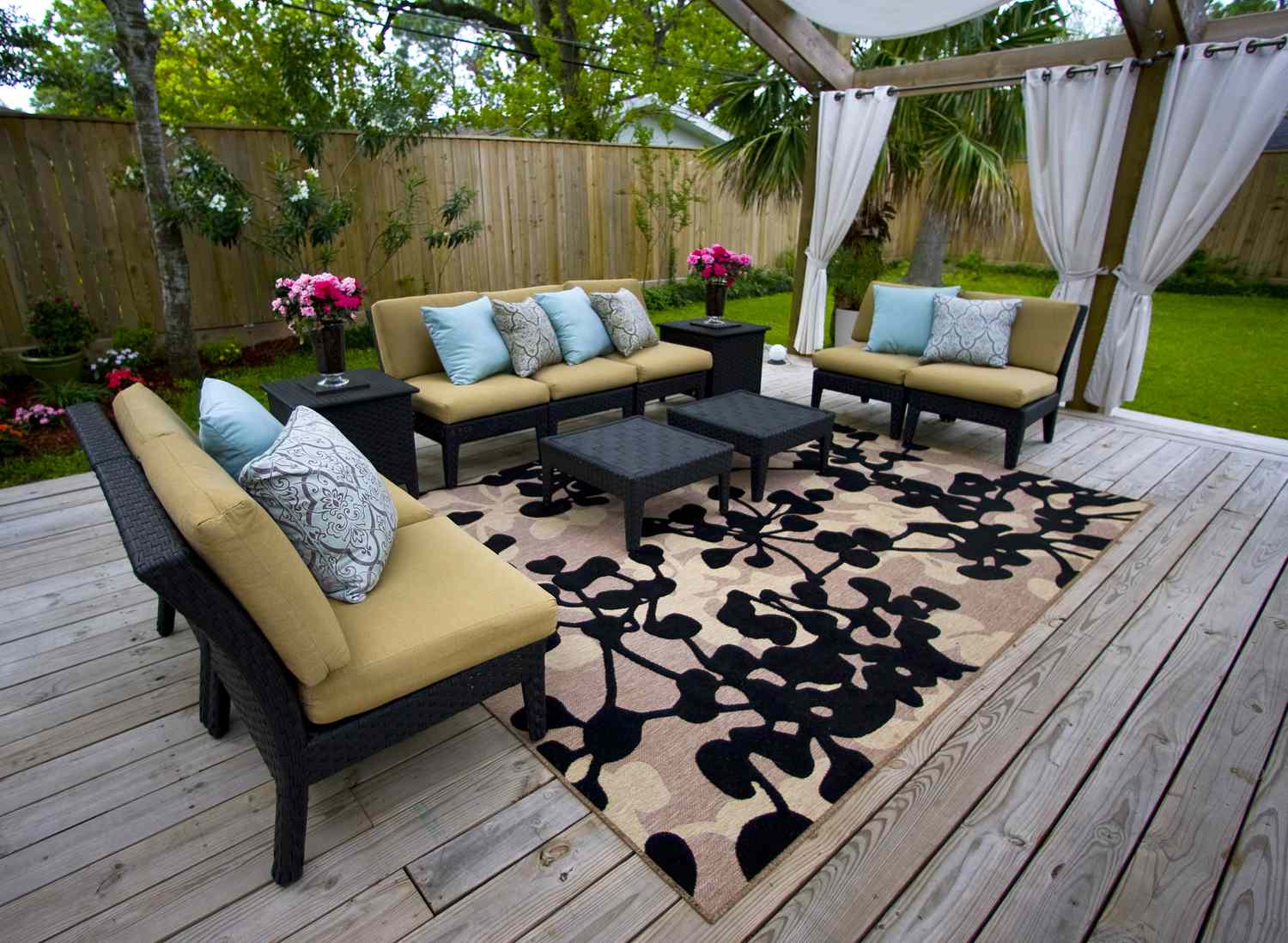 Holzpergola mit weißen Außenvorhängen 