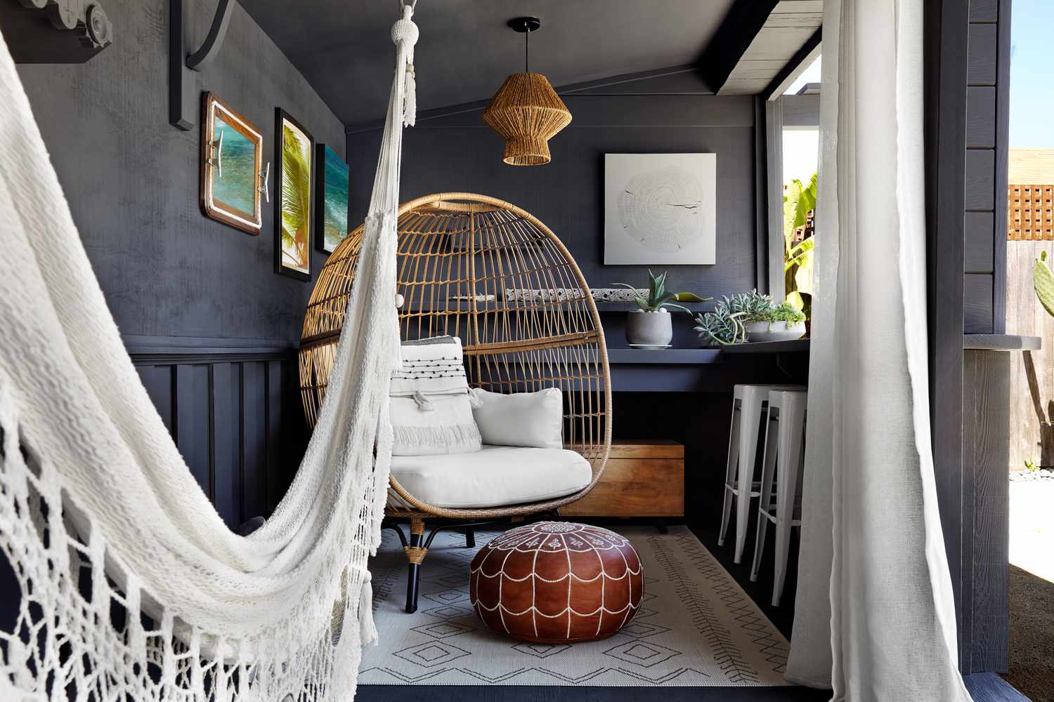 Boho-Terrassenbereich mit Vorhängen, Eierstuhl und Hängematte. 