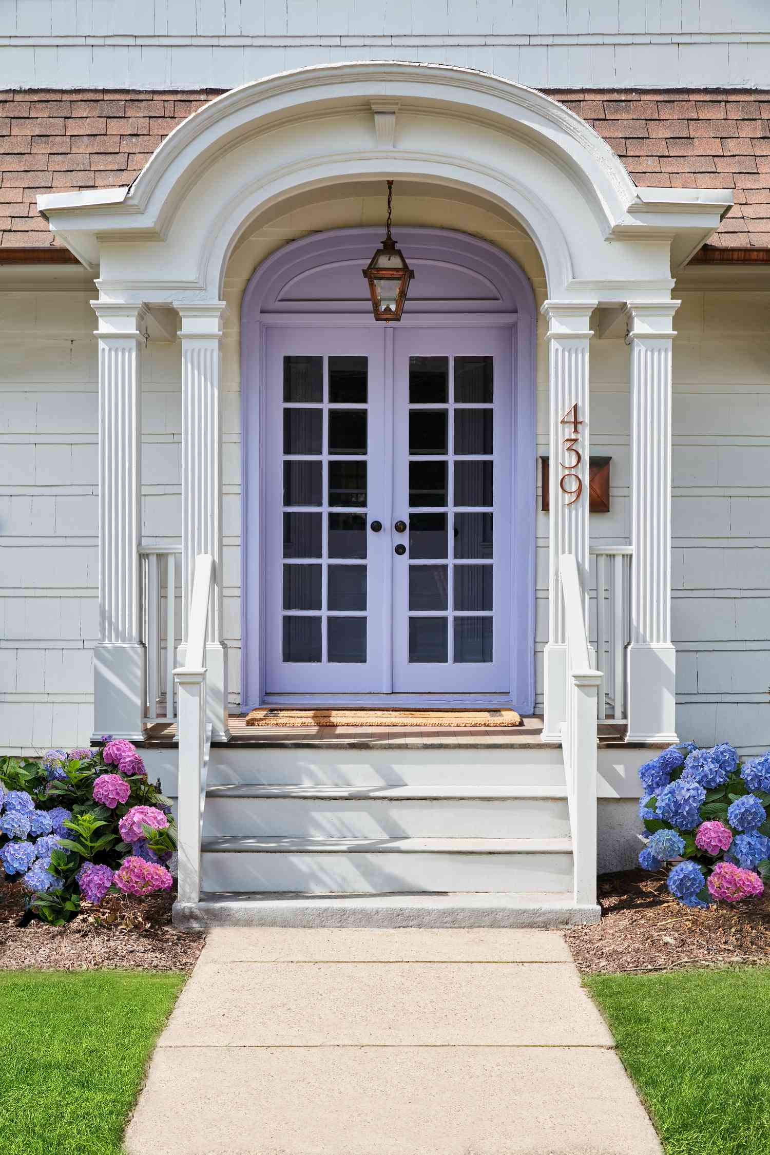 Lavendar -Haustür mit weißer Veranda