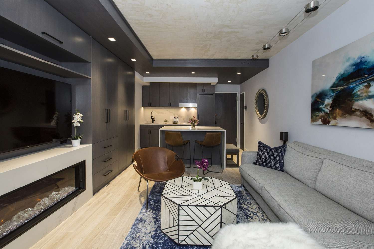 Wohnzimmer Wohnzimmer mit Graustufen, einem Cognac Leder -Hoop -Akzentstuhl und weißer und schwarzer hexagonaler Kaffeetisch