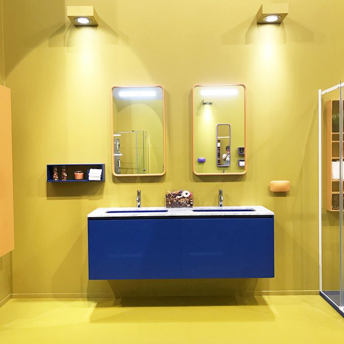 gelbes Badezimmer mit blauem Waschbecken und blauem Schwimmboxregal