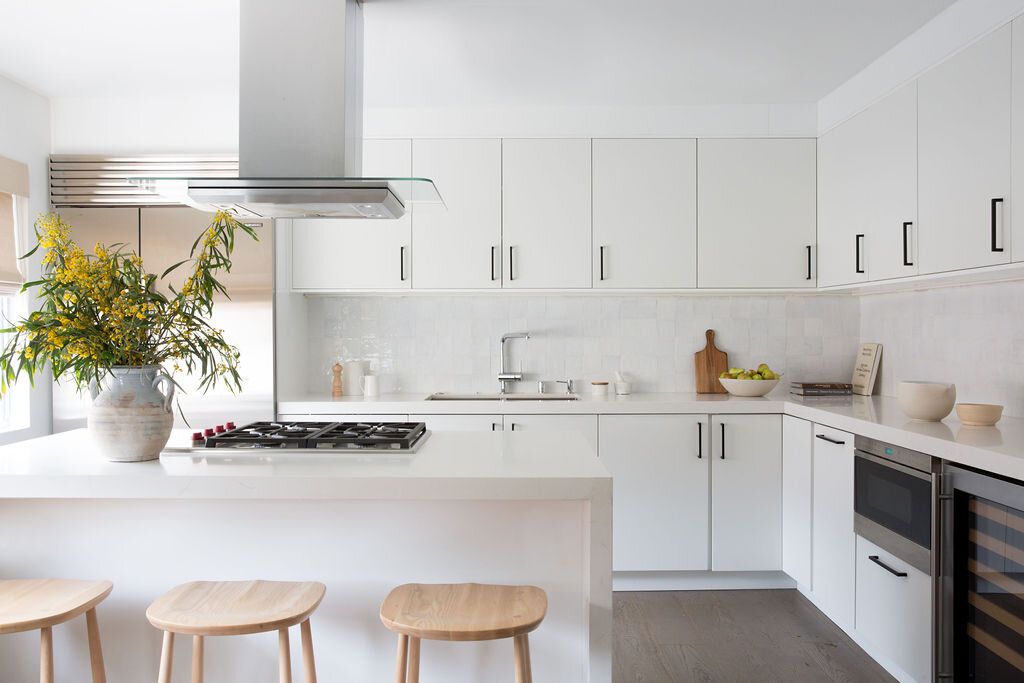 Wie man eine Designerküche bekommt, ohne die Bank zu brechen, so Decor Profis 6 Alle weiße Küche mit Holzstabsitzen und gelben Blumenstrauß