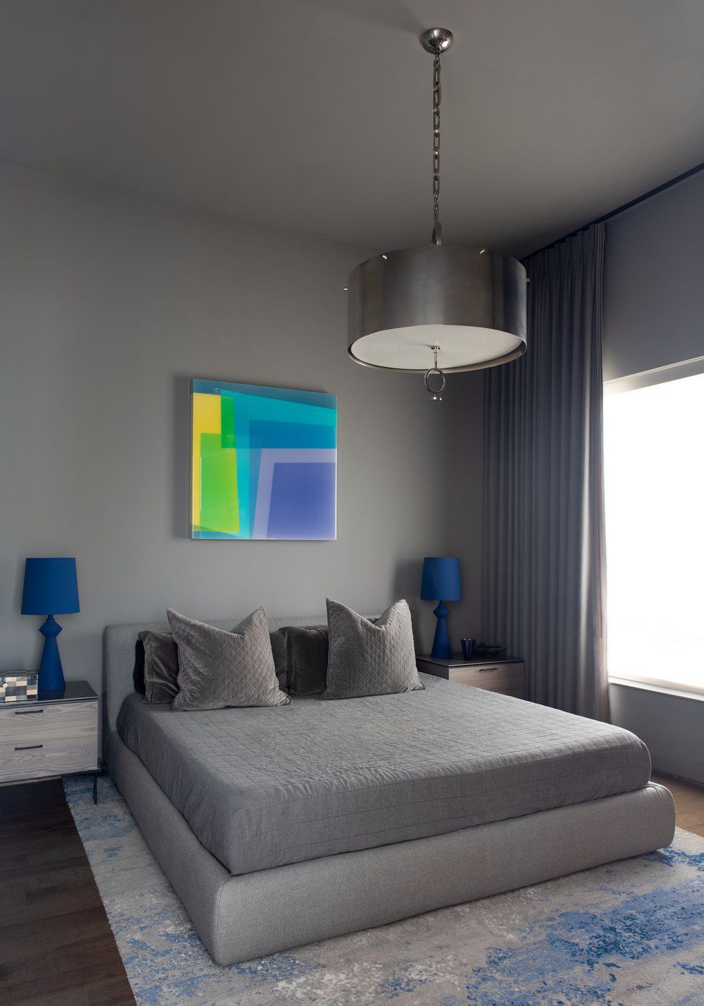 Einfaches graues Schlafzimmer mit moderner Kunst