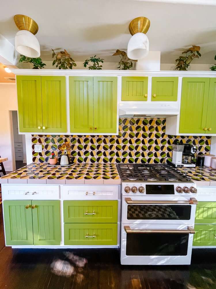 10 geniale Möglichkeiten, um einer stumpfen Küche einen Farbtupfer hinzuzufügen, teilen Designer 10 Eine farbenfrohe Küche mit grünen Schränken und gemusterten Blacksplash -Fliesen