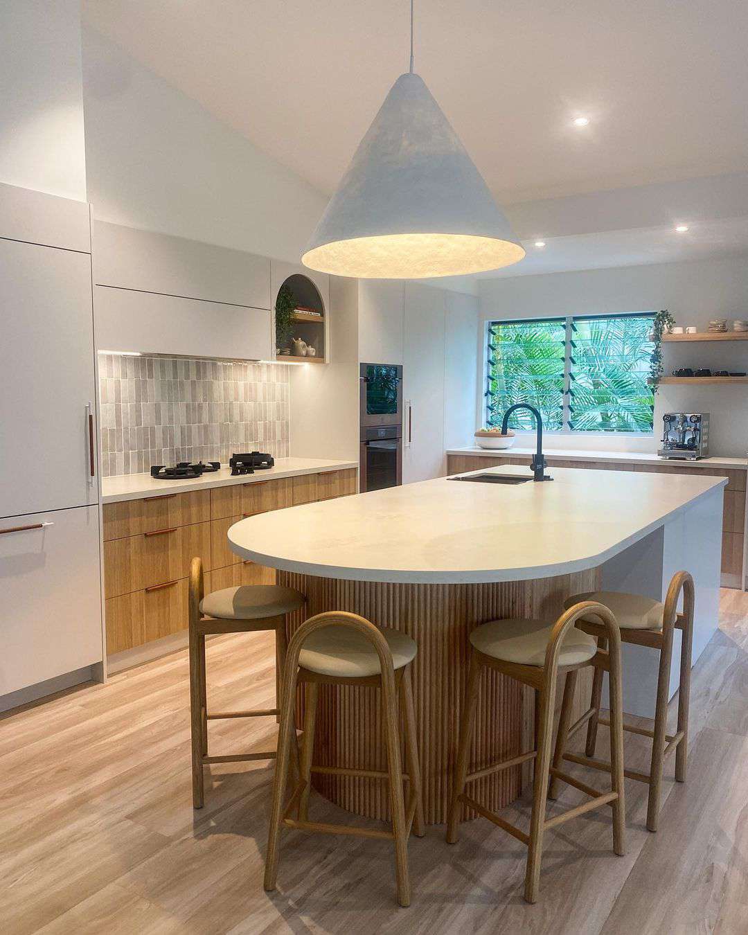 A neutral kitchen with a large pendant light