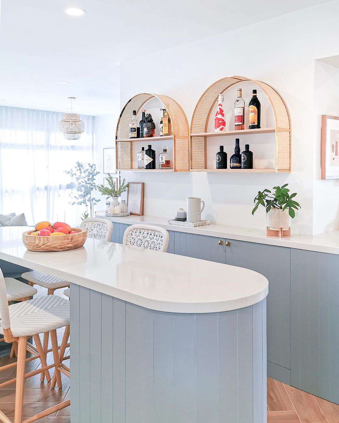 A soft blue curved kitchen island