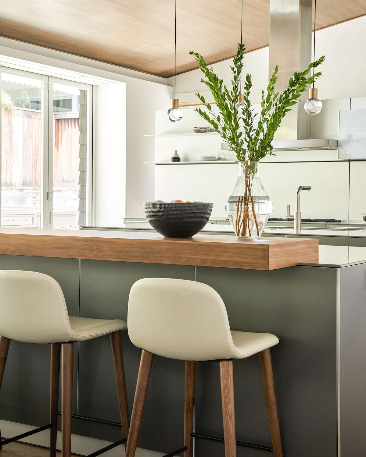 A kitchen island with a wooden bar top