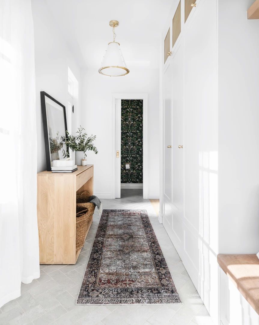 Narrow hallway with built-ins on one side and a console on the other