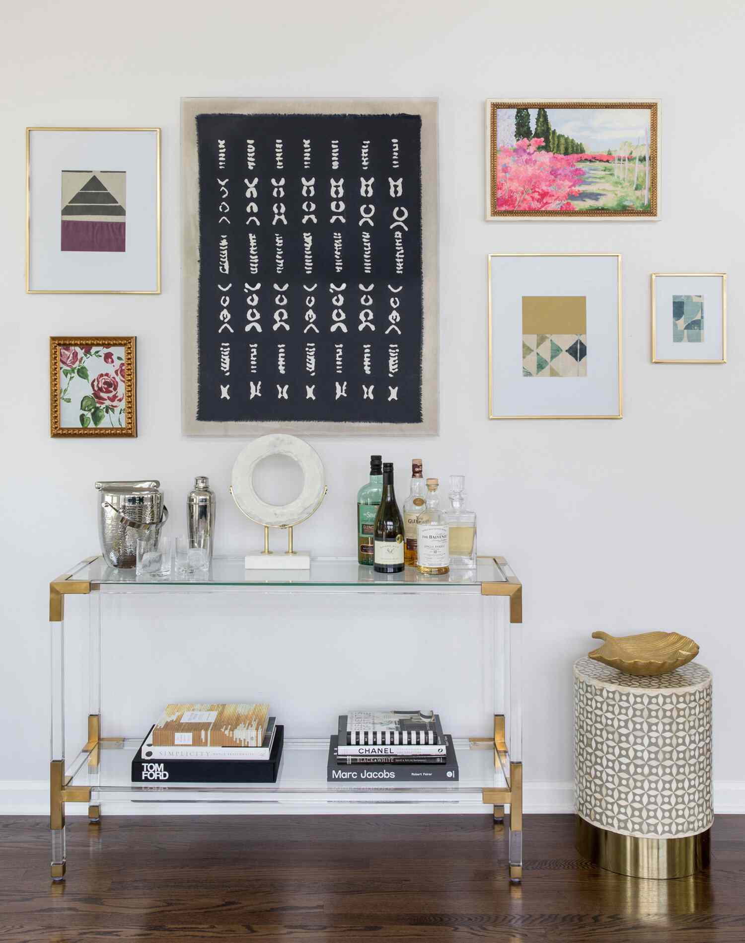 Acrylic console and small table with a gallery wall above it