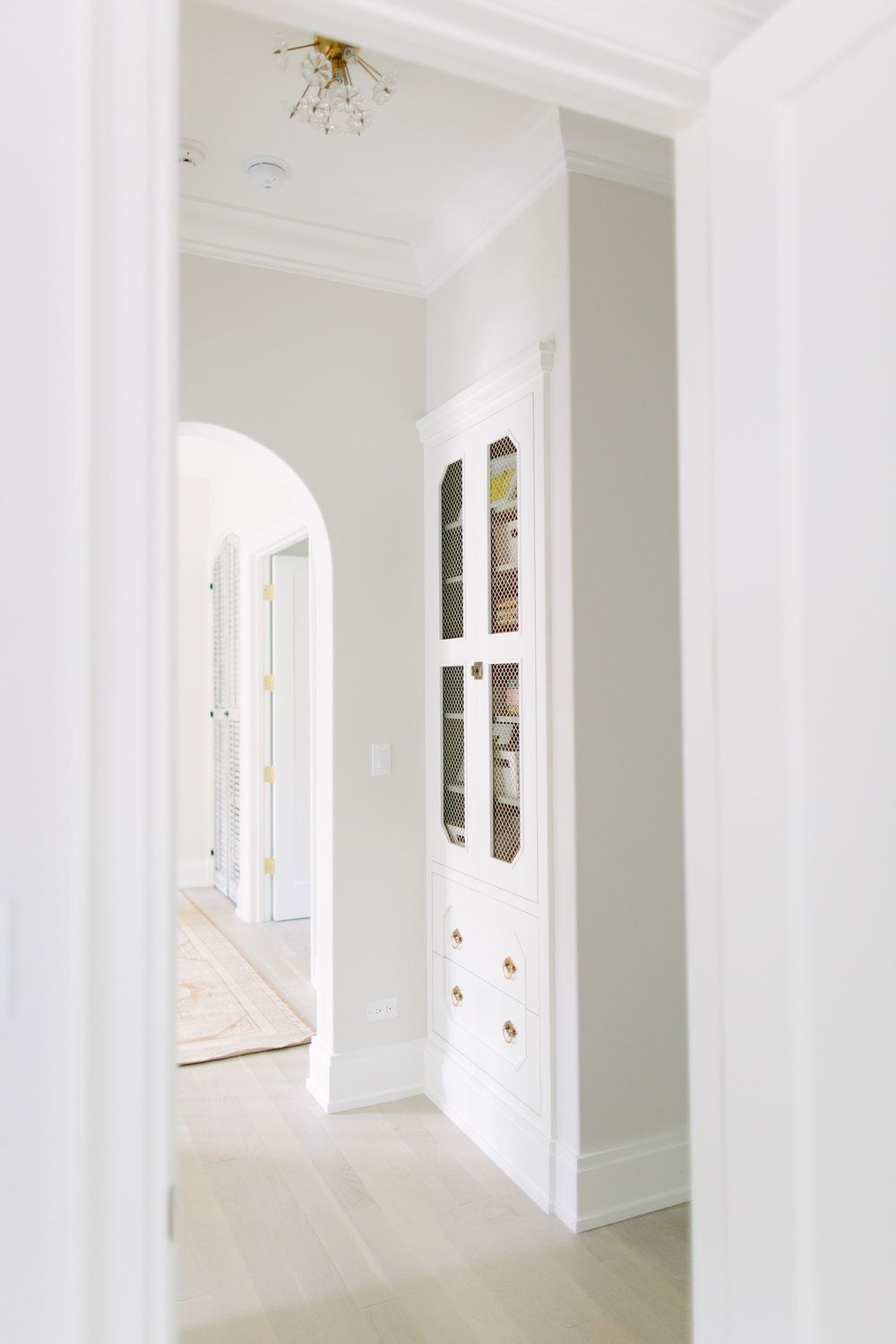 Built-in cabinet in a narrow hallway with off-white walls