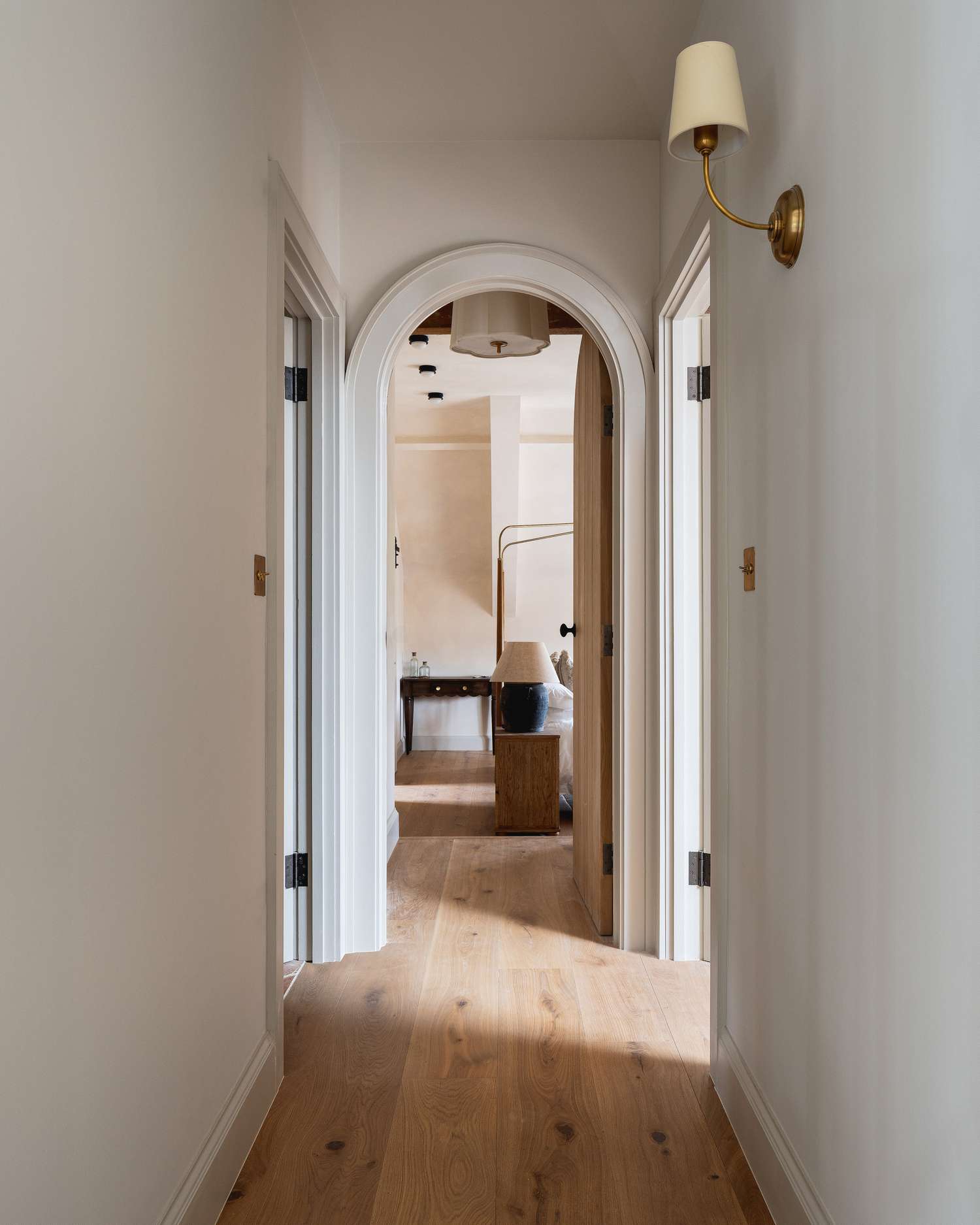 Hallway with a brass wall sconce with a white shade