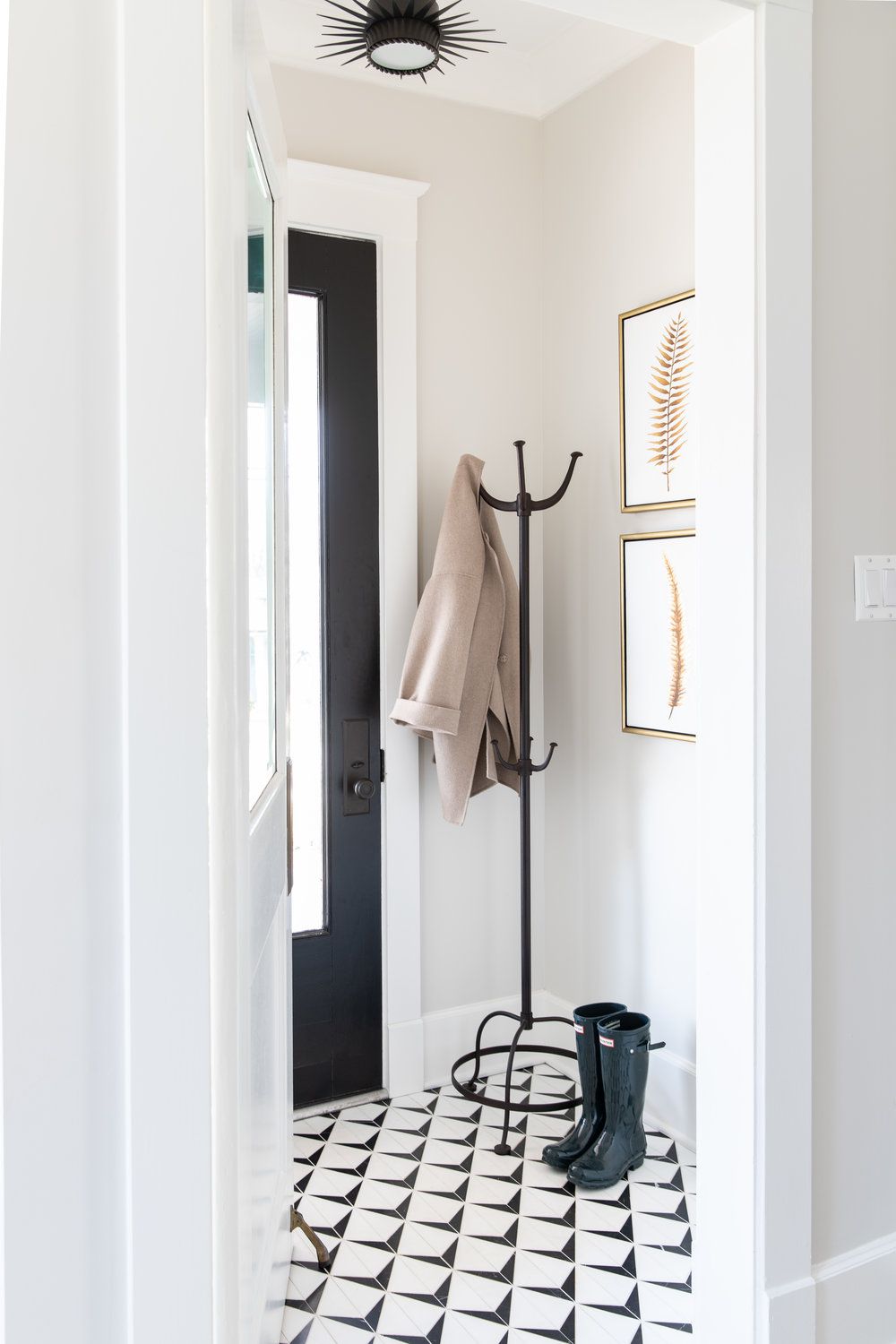 Black coat rack in a narrow hallway