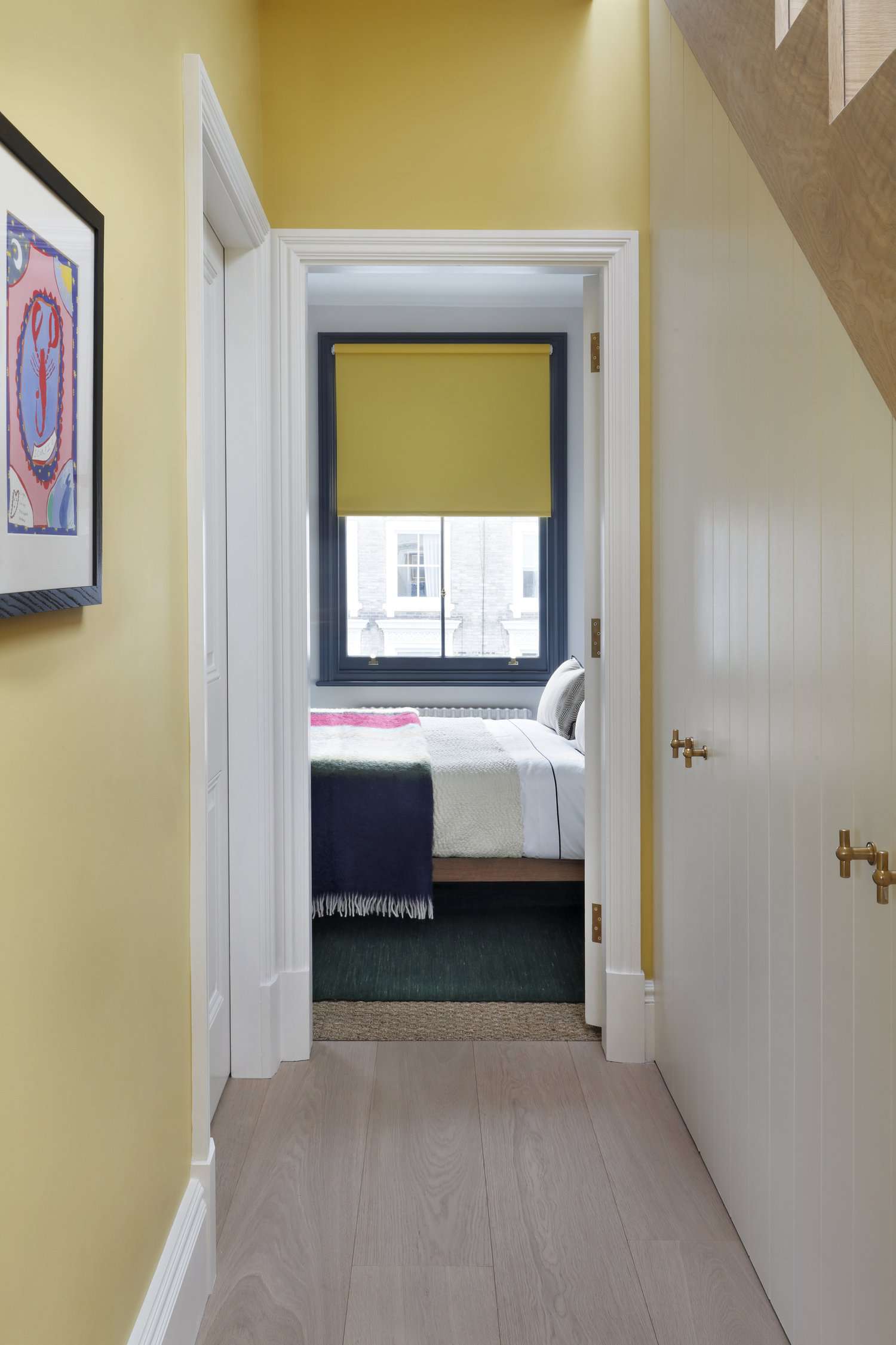 Storage cabinets under a staircase in a narrow hallway