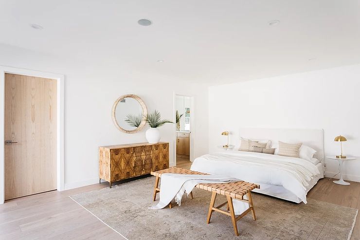 Verschwenden Sie Ihr Geld nicht für diese Möbelstücke, warnen Designer 10 Strandneutrales Schlafzimmer mit Bank am Fuß des Bettes.