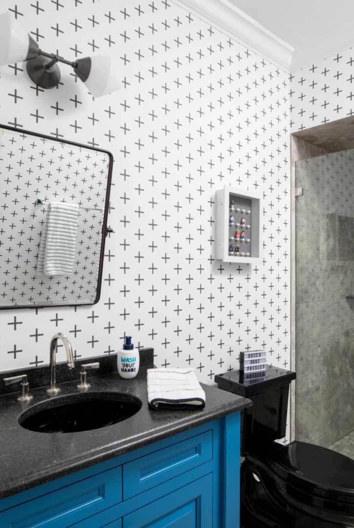 A kid's bathroom with a bright blue vanity and Legos decor