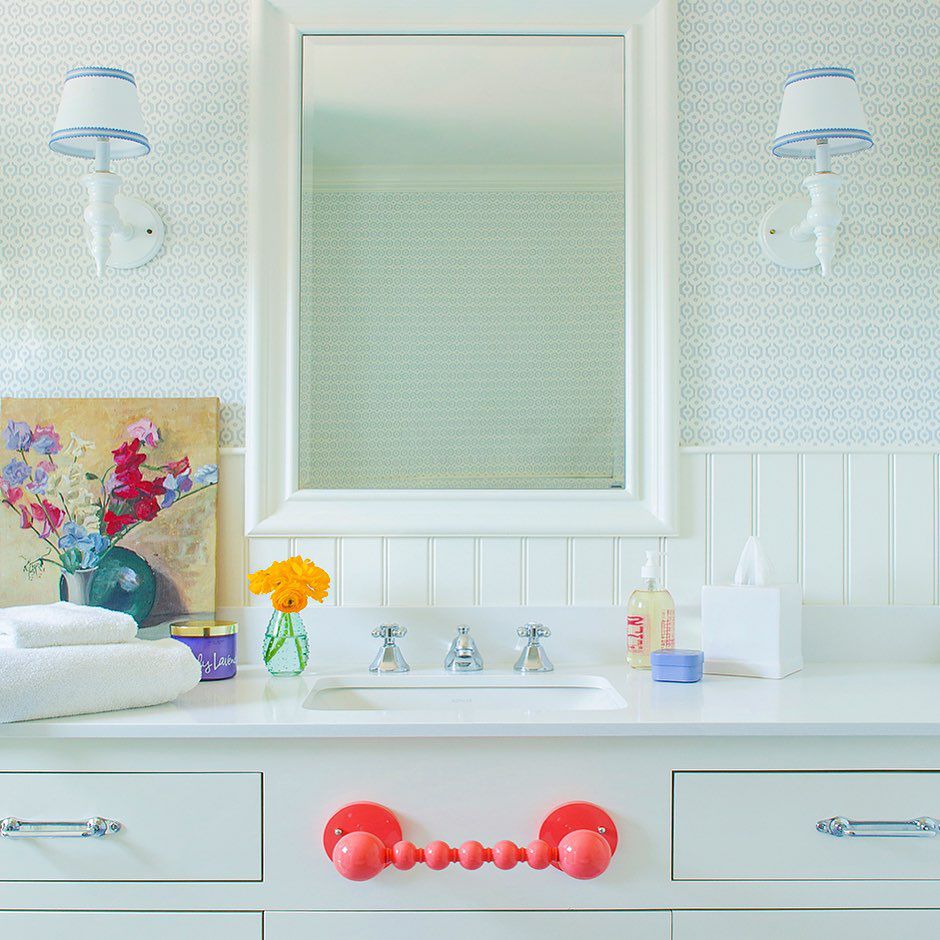 Bathroom with patterned wallpaper and pink towel rack
