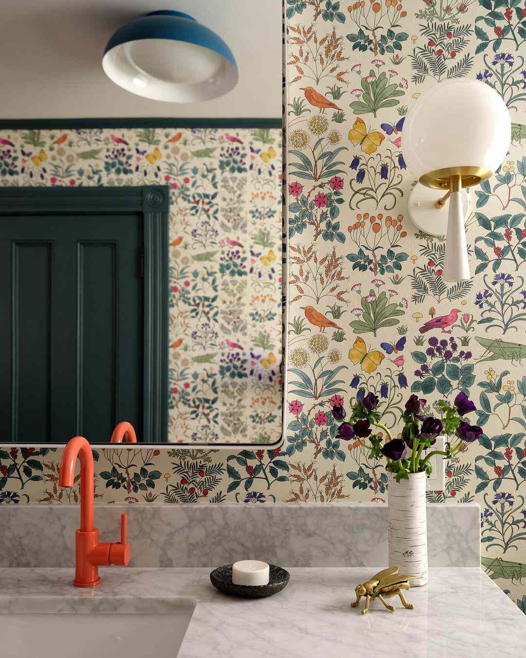 Floral wallpaper in bathroom with light fixtures