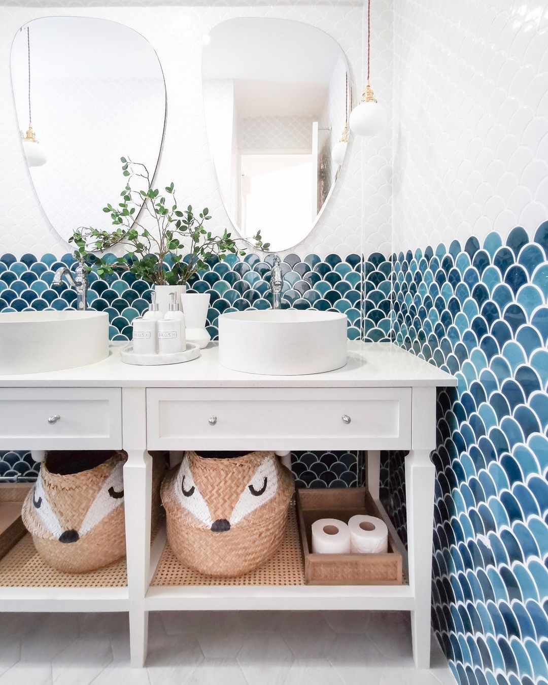 Kids' bathroom with whimsical storage baskets on open vanity cabinet shelf