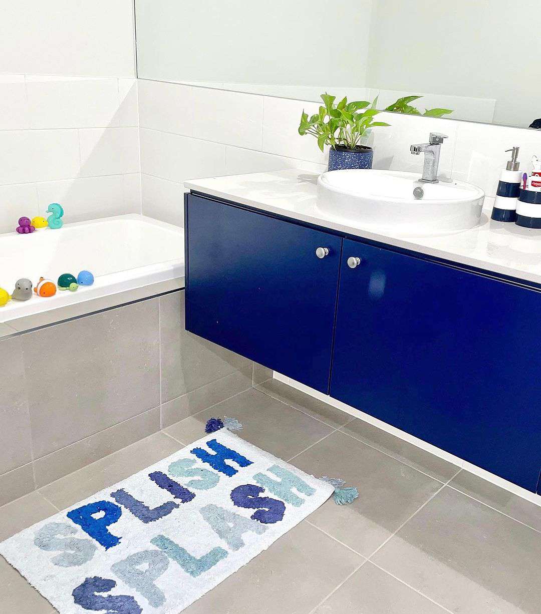 Blue bathroom cabinet with toys around tub