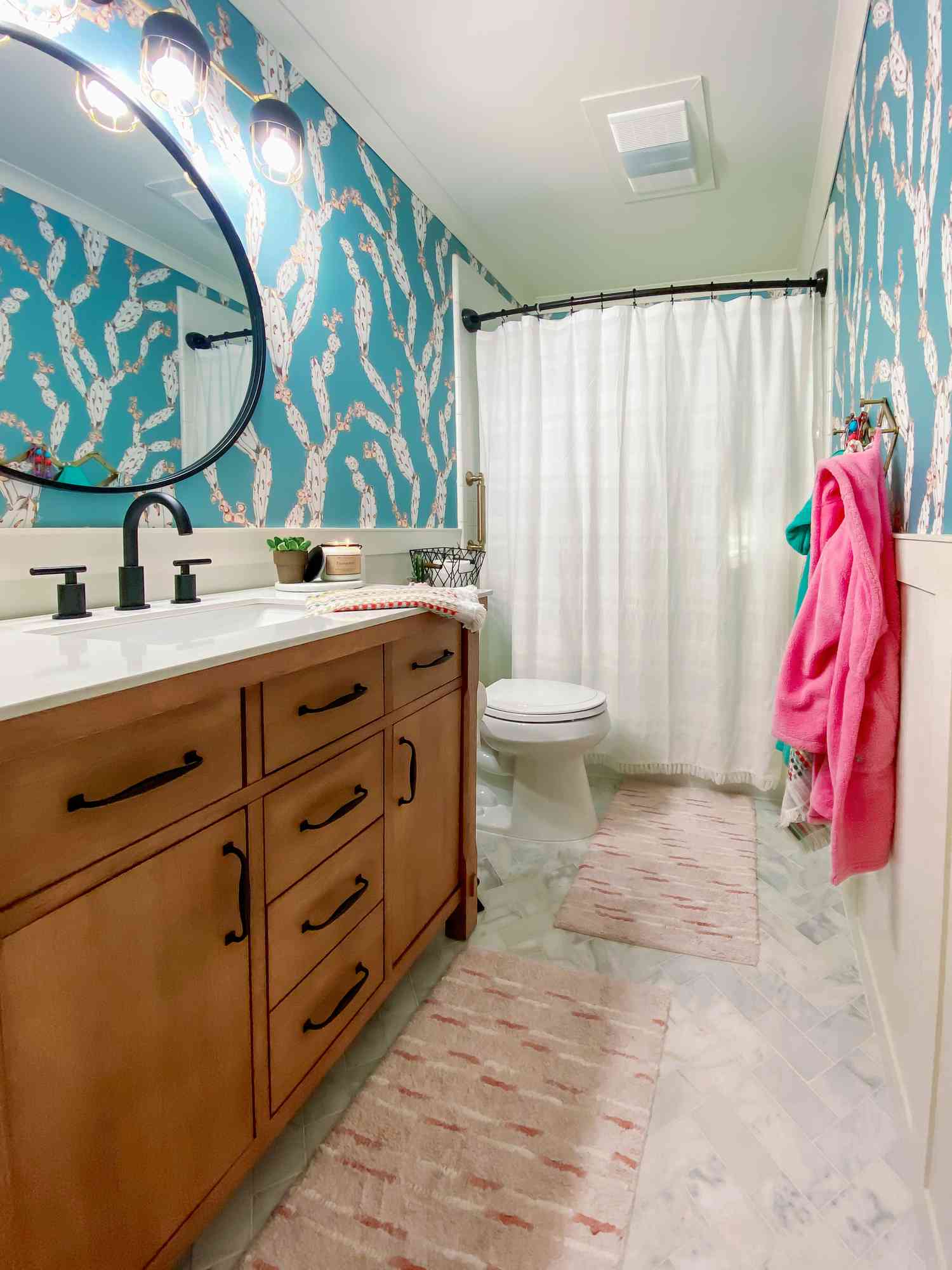 Aqua blue wallpapered bathroom and pink towel