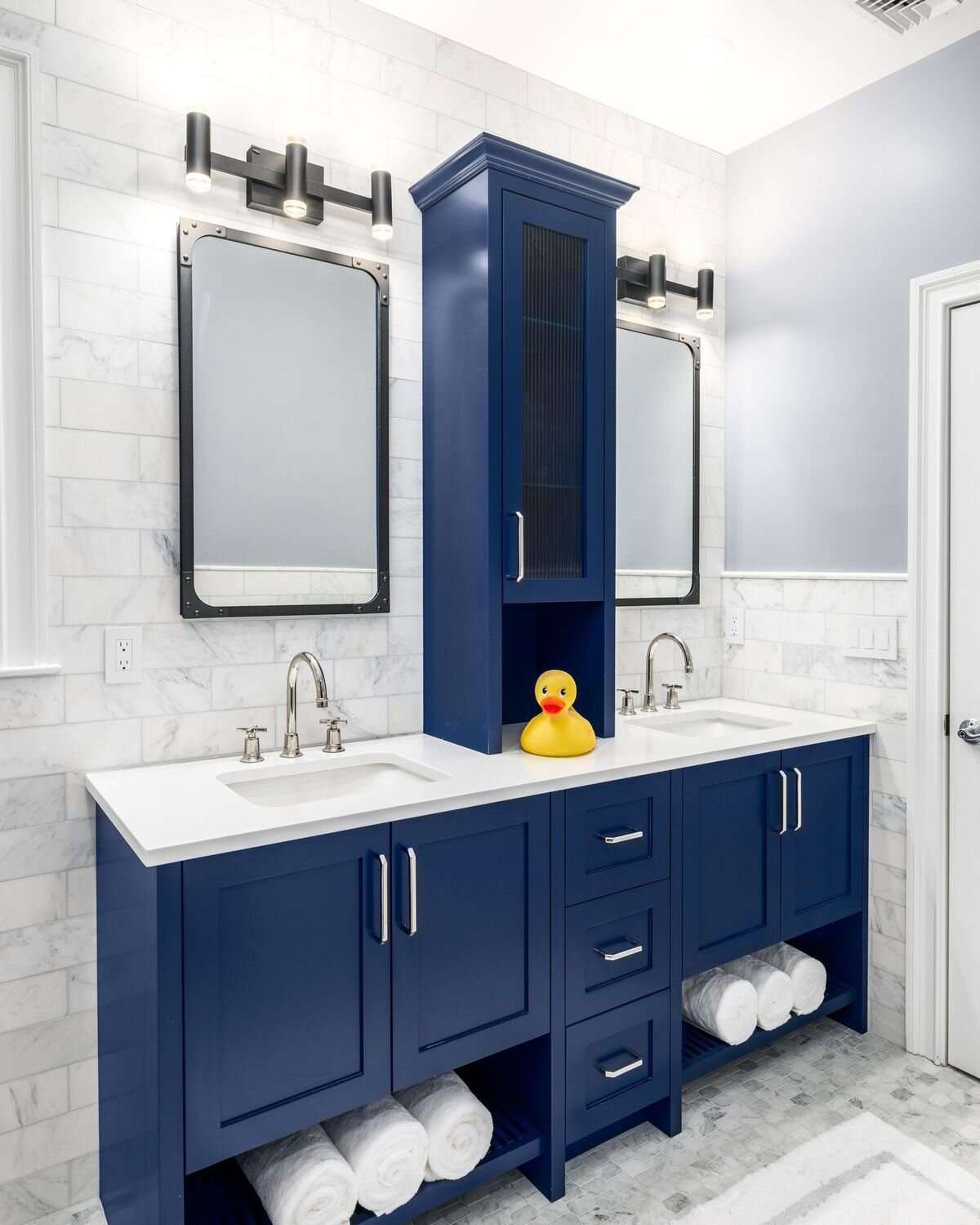 Bathroom with blue cabinets and gray tiles