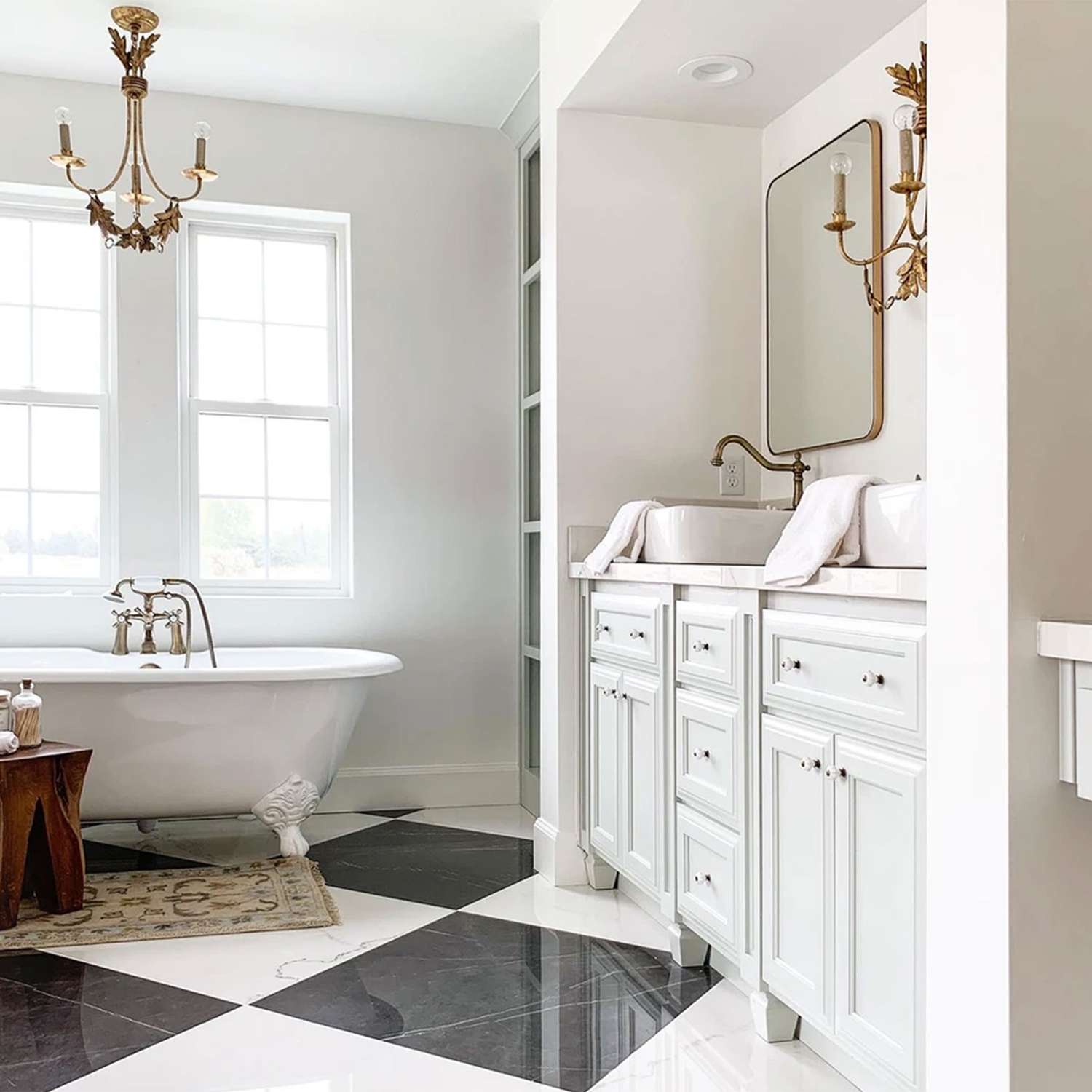 5 Things Designers Immediately Notice About a Bad Bathroom Layout 8 Ashley Webb Interiors bathroom with multiple lighting sources, clawfoot tub, vessel sink, and ample storage.