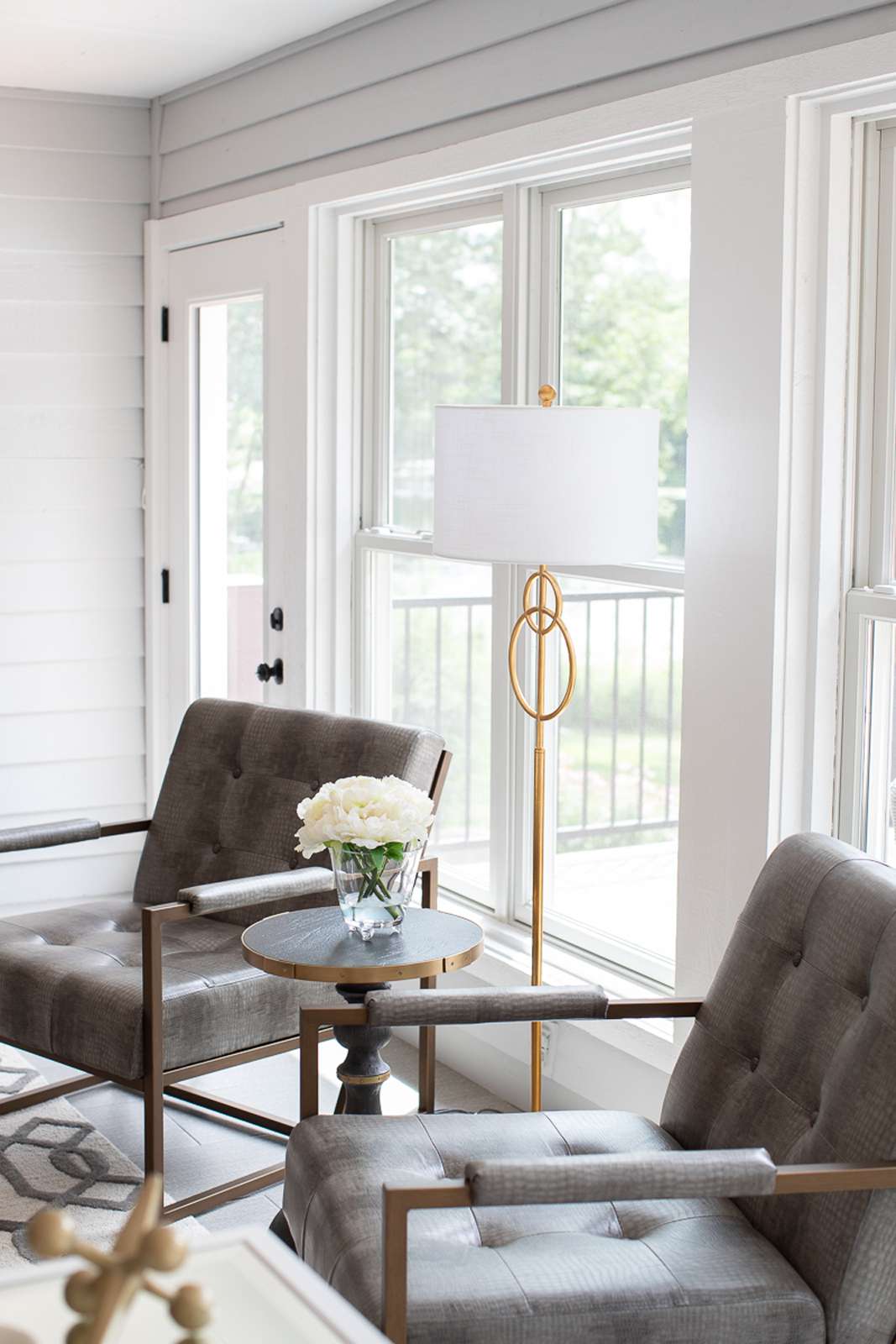 48 Small Sunroom Ideas for a Warm and Happy Space 4 Modern furniture and a white and gold floor lamp in a small sunroom with light gray walls