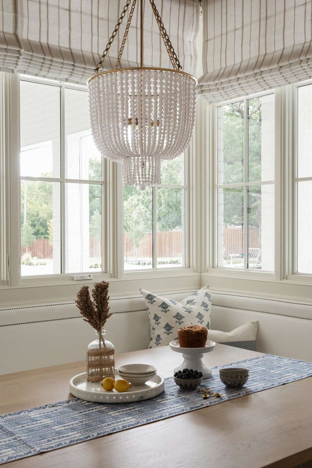 48 Small Sunroom Ideas for a Warm and Happy Space 38 Sunroom breakfast nook with striped window shades and a beaded chandelier