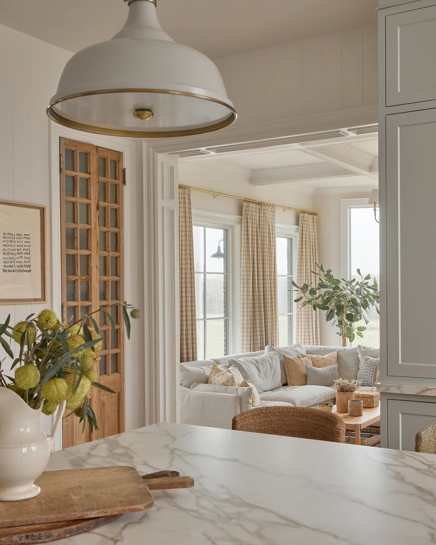 48 Small Sunroom Ideas for a Warm and Happy Space 28 Patterned curtain panels in a white sunroom with a potted tree in the corner and a deep sectional