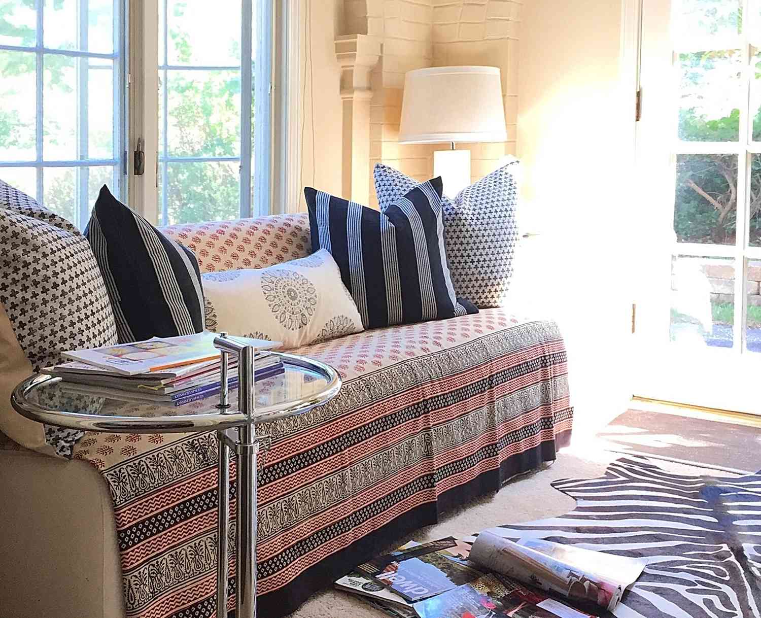 48 Small Sunroom Ideas for a Warm and Happy Space 40 Daybed with patterned throw, pillows, and rug in a bright sunroom